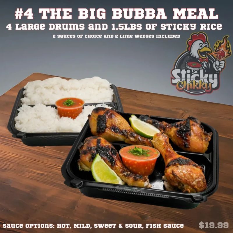 Two black meal boxes: one loaded with four large drumsticks and lime wedges, one with a large portion of sticky rice and a red sauce cup