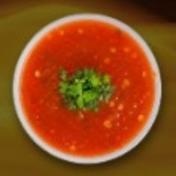 Bright red sauce with green herb garnish in a white bowl