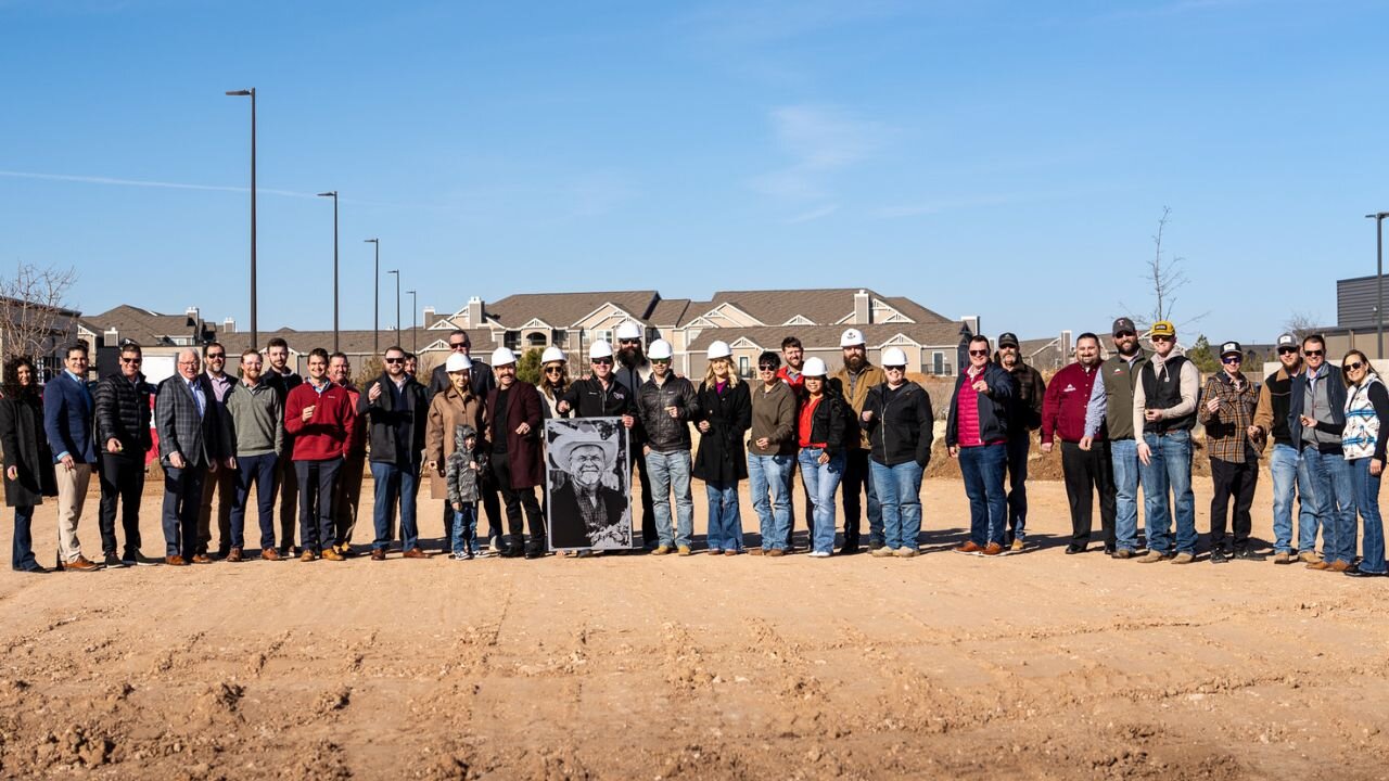 The Sticky Chikky team and community partners gathered at a groundbreaking event, wearing hard hats and smiling together outdoors in Amarillo, TX
