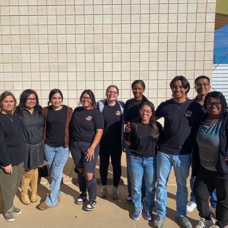 Sticky Chikky team members smiling together outside a community venue after a Spirit Night event